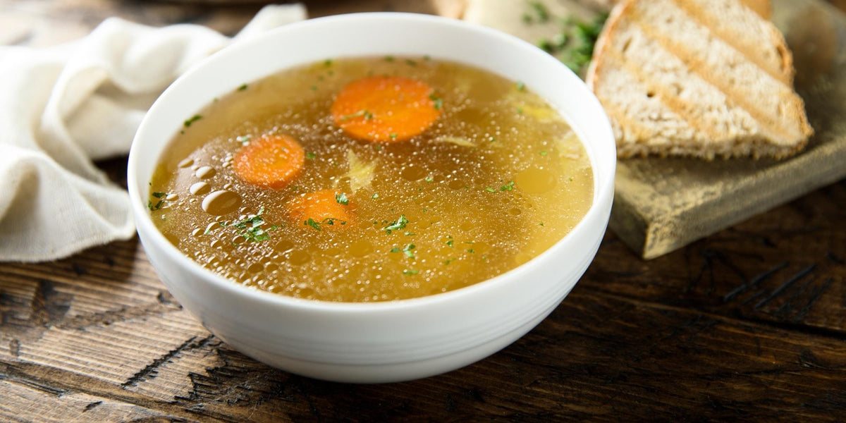 Chicken stock in a white bowl.