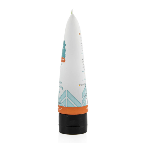 White tube of detoxifying clay face mask stands against a white background.