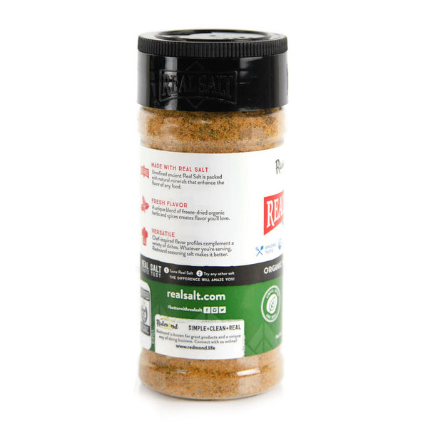 Clear shaker of Redmond Real Salt seasoning salt against a white background.