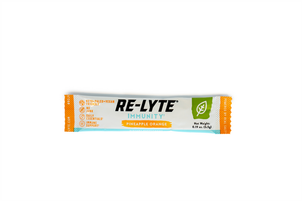 A single-serving packet of Re-Lyte Immunity Pineapple Orange dietary supplement lies horizontally against a white background.