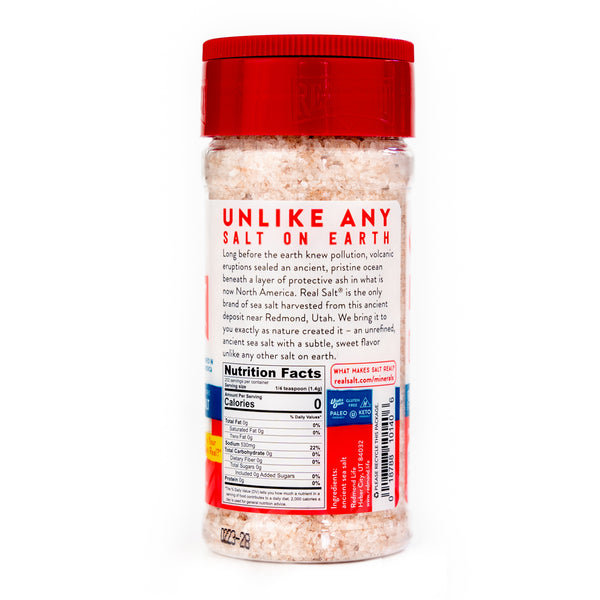 Clear plastic jar filled with Real Salt brand pink Himalayan sea salt and a red lid.