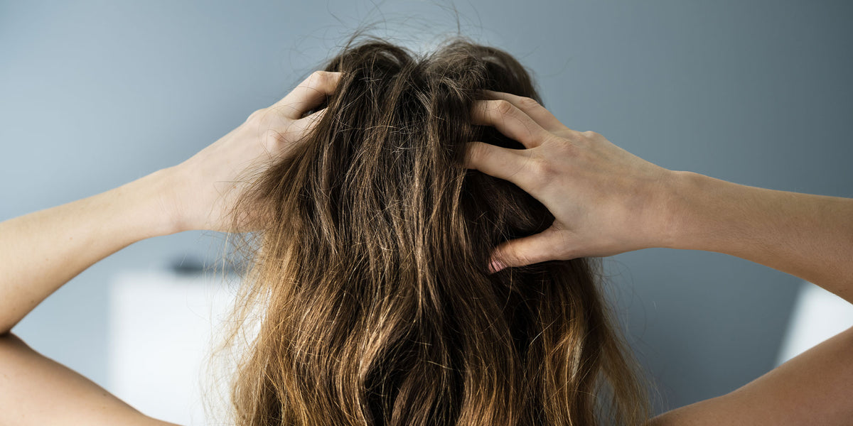 Woman putting dry shampoo in her hair
