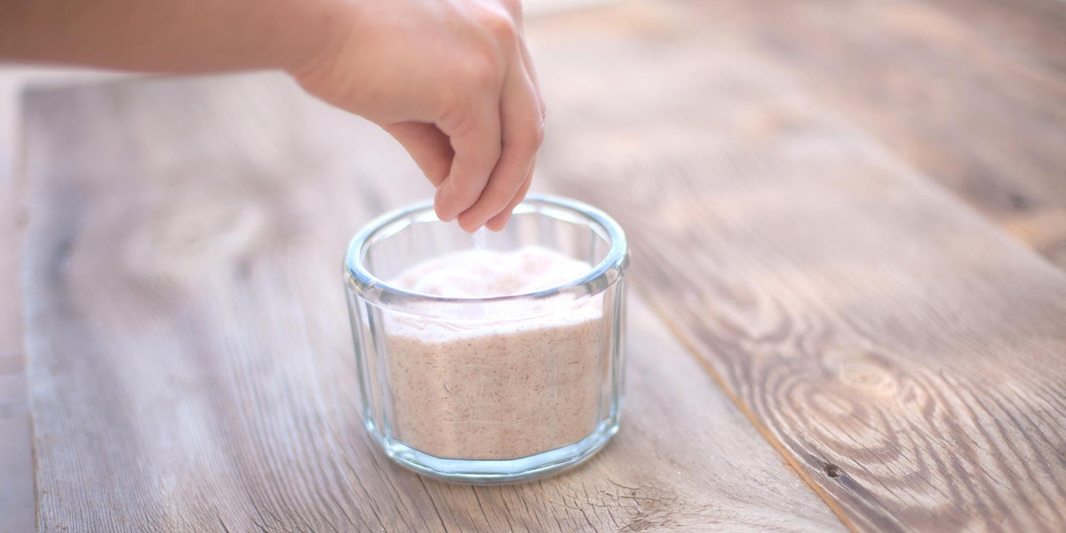hand grabbing a dash of Redmond Real Salt from a glass dish