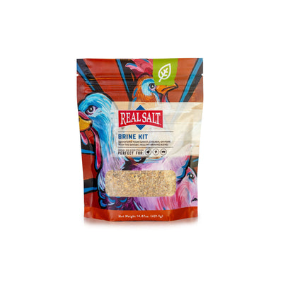 Real Salt Brine Kit stands in a colorful package, featuring illustrations of a chicken and pig, showcasing the savory blend perfect for brining poultry and pork. 
