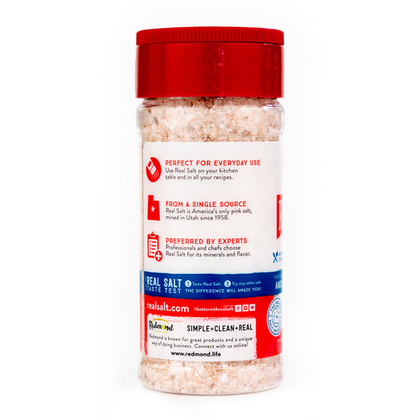 Clear shaker filled with Redmond Real Salt, a pink ancient sea salt mined in Utah.